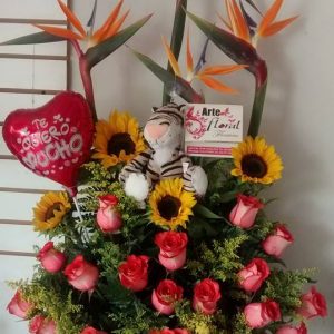 Arreglo con aves del paraíso y girasoles, peluche y rosas salmón iguana